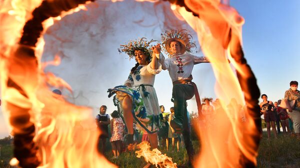 Девушка и юноша прыгают через огонь на празднике Ивана Купалы на берегу залива Припяти в древнем белорусском Турове - Sputnik Литва