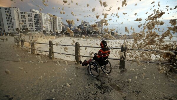 Человек в инвалидной коляске фотографирует морскую пену в Кейптауне - Sputnik Lietuva