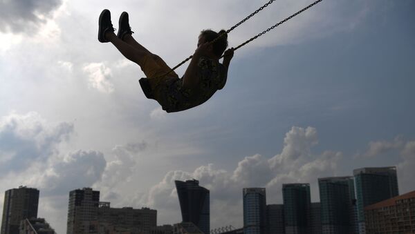 Девочка катается на качелях в парке, архивное фото - Sputnik Lietuva