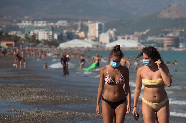 Девушки в защитных масках на пляже Мизерикордия в Малаге, Испания  - Sputnik Литва