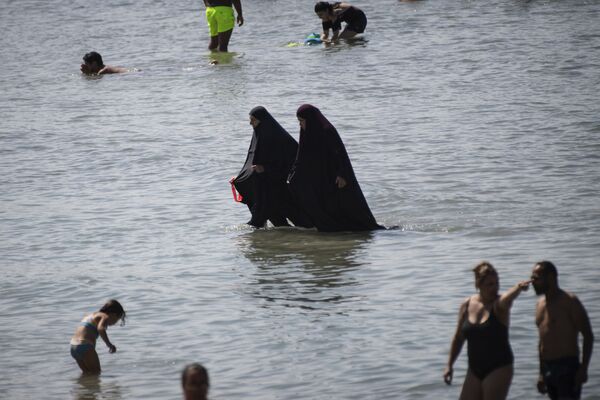 Мусульманки в чадре купаются в море на пляже в Марселе, Франция  - Sputnik Литва