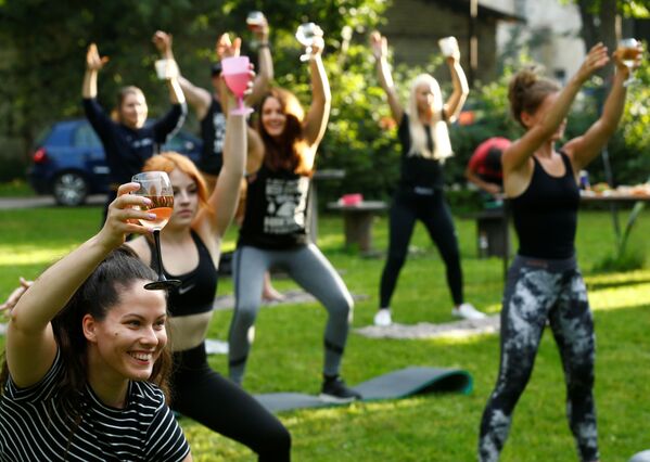Люди с бокалами вина во время йоги в Латвии  - Sputnik Lietuva