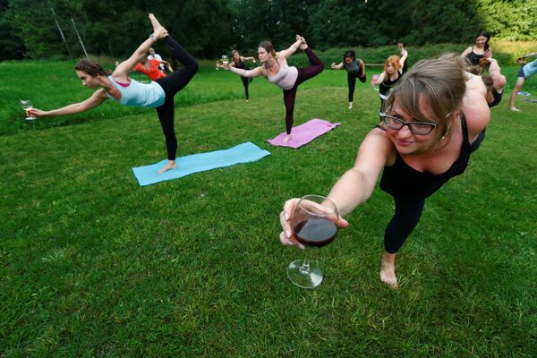 Люди с бокалами вина во время йоги в Латвии  - Sputnik Литва