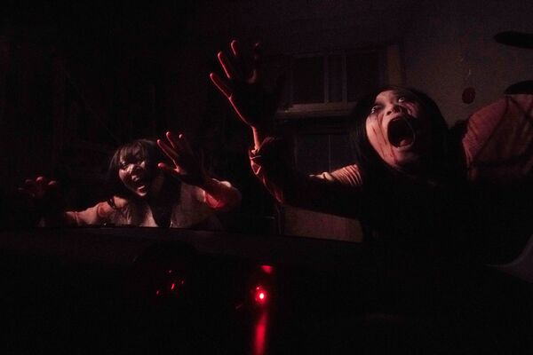 Зомби у окна автомобиля во время демонстрации дома с привидениями в Токио - Sputnik Литва