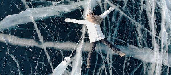 Девушка лежит на льду замерзшего Байкала - Sputnik Lietuva