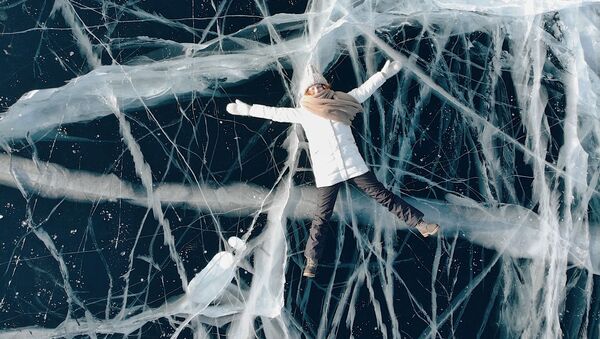 Девушка лежит на льду замерзшего Байкала - Sputnik Lietuva