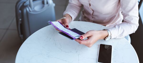 Девушка с билетом и паспортом в аэропорту - Sputnik Литва