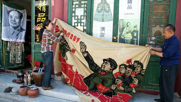 Pardavėjai laiko 1969 metų plakatą su buvusio Kinijos lyderio Mao Dzedongo atvaizdu antikvariniame turguje Pekine, Kinija - Sputnik Lietuva