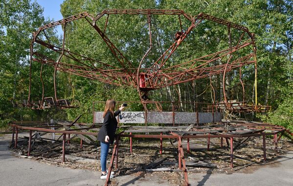 Туристка у качелей в зоне отчуждения Чернобыльской АЭС - Sputnik Литва