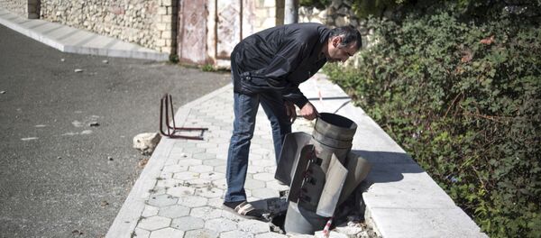 Местный житель у неразорвавшегося снаряда на улице города Мартуни Местный житель у неразорвавшегося снаряда на улице города Мартуни - Sputnik Lietuva