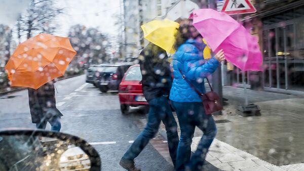 Люди переходят дорогу в городе в дождь - Sputnik Lietuva