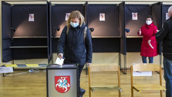 Женщина опускает свой бюллетень на избирательном участке во время второго тура парламентских выборов в Вильнюсе, 25 октября 2020 года - Sputnik Литва