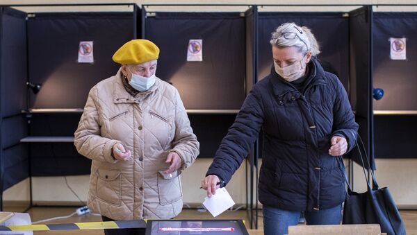 Женщины голосуют на избирательном участке во время второго тура парламентских выборов в Вильнюсе, 25 октября 2020 года - Sputnik Литва