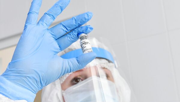 Медсестра держит в руках ампулу с российской вакциной Гам-Ковид-Вак от коронавируса - Sputnik Lietuva