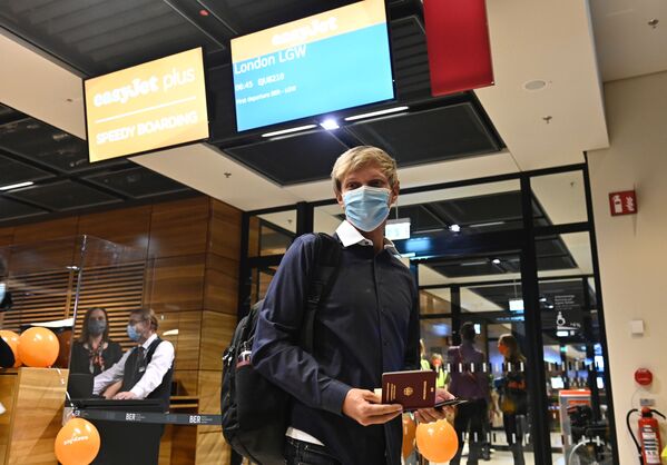 Пассажир в медицинской маске в новом международном аэропорту Берлин-Бранденбург имени Вилли Брандта в Германии - Sputnik Литва