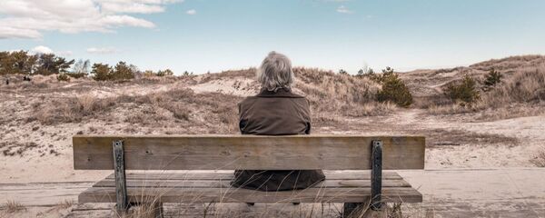 Пожилая женщина сидит на скамейке Пожилая женщина сидит на скамейке - Sputnik Lietuva