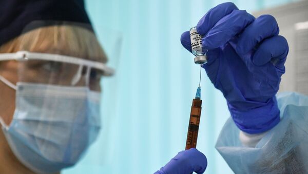 Медсестра держит шприц перед вакцинацией от коронавируса пациента - Sputnik Литва