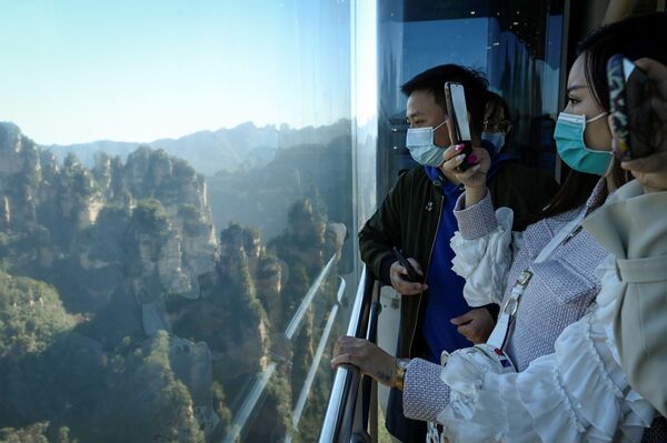 Туристы фотографирую окрестности во время поездки в лифте Байлун в национальном парке Чжанцзяцзе в провинции Хунань, Китай - Sputnik Литва