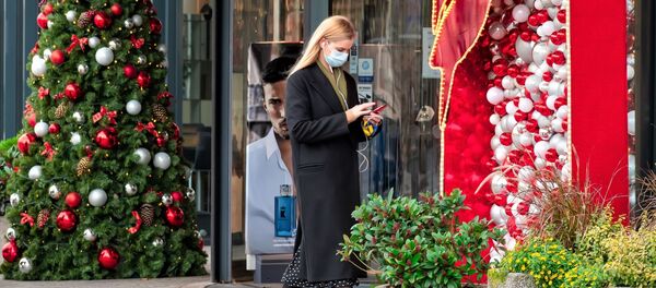 Девушка в медицинской маске идет возле магазина, Вильнюс - Sputnik Литва