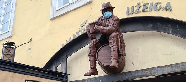 Фигура пьяницы над входом в кафе в медицинской маске, Вильнюс Фигура пьяницы над входом в кафе в медицинской маске, Вильнюс - Sputnik Lietuva