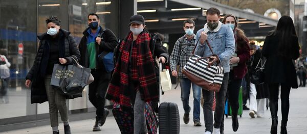 Люди в защитных масках на улице Лондона Люди в защитных масках на улице Лондона - Sputnik Lietuva