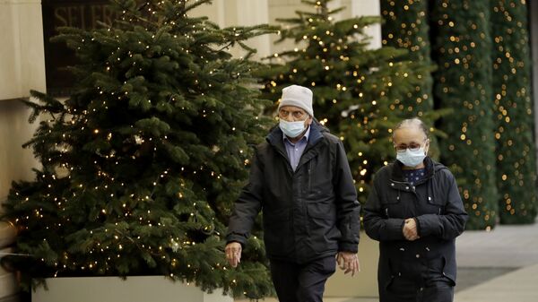 Люди в масках проходят мимо рождественских елок в Лондоне - Sputnik Lietuva