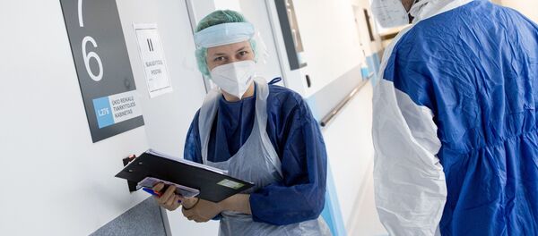 Медработники в защитных костюмах в Вильнюсской университетской клинической больнице Сантарос  - Sputnik Литва