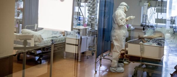 Медработник в защитном костюме в Вильнюсской университетской клинической больнице Сантарос  - Sputnik Литва
