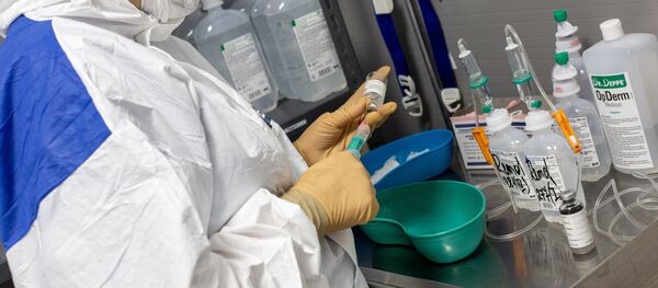 Медработник в защитном костюме в Вильнюсской университетской клинической больнице Сантарос Медработник в защитном костюме в Вильнюсской университетской клинической больнице Сантарос - Sputnik Lietuva