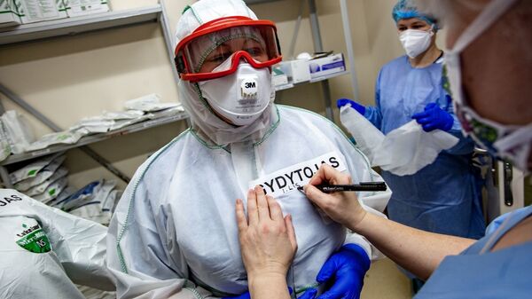 Медработники в защитных костюмах в Вильнюсской университетской клинической больнице Сантарос  - Sputnik Литва