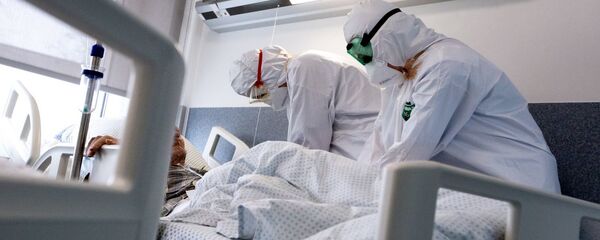 Медработники в защитных костюмах в Вильнюсской университетской клинической больнице Сантарос  - Sputnik Литва