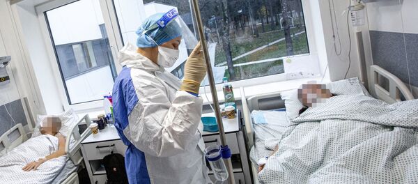 Медработник в защитном костюме в Вильнюсской университетской клинической больнице Сантарос Медработник в защитном костюме в Вильнюсской университетской клинической больнице Сантарос - Sputnik Lietuva