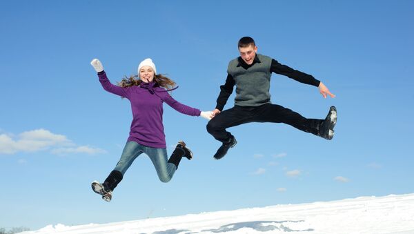 Подпрыгнувшая пара на фоне снега и голубого неба - Sputnik Литва