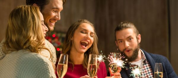 Молодые люди с бокалами шампанского и бенгальскими огнями  - Sputnik Lietuva