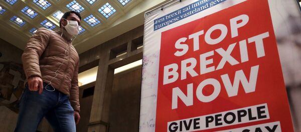 Мужчина проходит мимо рекламного щита с надписью: Остановить Брексит сейчас Мужчина проходит мимо рекламного щита с надписью: Остановить Брексит сейчас - Sputnik Литва