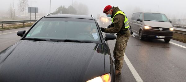 Полицейский проверяет машину на блокпосту под Вильнюсом, Литва Полицейский проверяет машину на блокпосту под Вильнюсом, Литва - Sputnik Lietuva