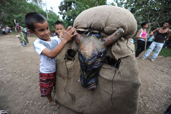 Мальчик играет с участником фестиваля Feast of the Devils в костюме быка в Коста-Рике  - Sputnik Lietuva