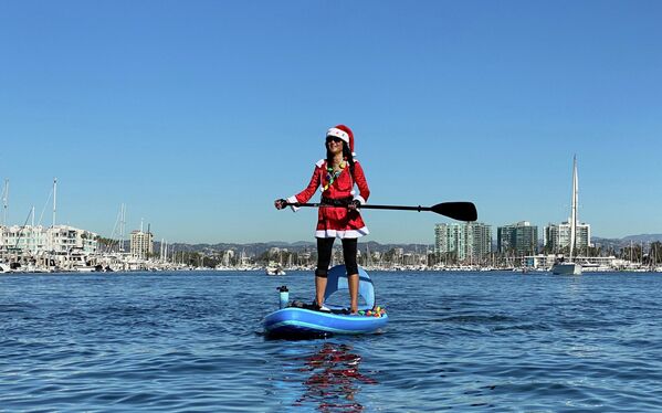 Девушка в костюме Санта-Клауса на SUP-серфе в Лос-Анджелесе, Калифорния - Sputnik Lietuva