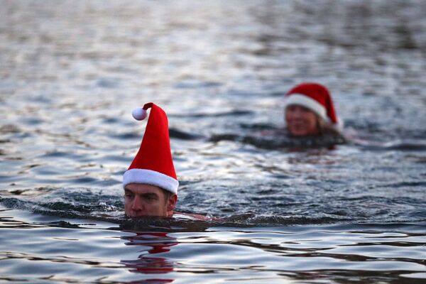 Люди в рождественских колпаках плаваю в озере Серпентин в Гайд-парке в Лондоне - Sputnik Lietuva