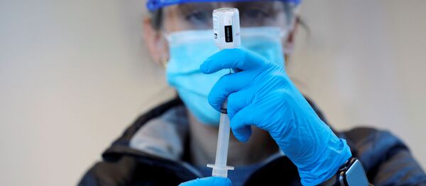 Медицинский работник набирает в шприц вакцину против коронавируса - Sputnik Литва