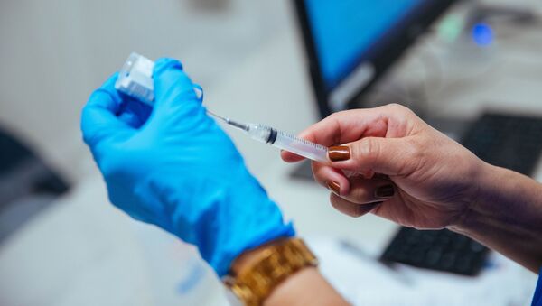 Медицинский работник набирает в шприц вакцину против коронавируса - Sputnik Литва