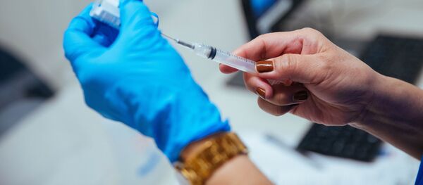 Медицинский работник набирает в шприц вакцину против коронавируса - Sputnik Литва