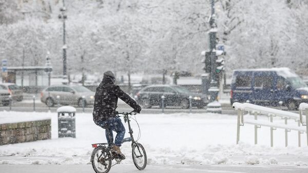 Велосипедист на заснеженной улице в Вильнюсе - Sputnik Литва