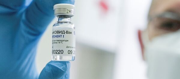 Медработник держит в руке российскую вакцину от коронавируса Спутник V - Sputnik Литва