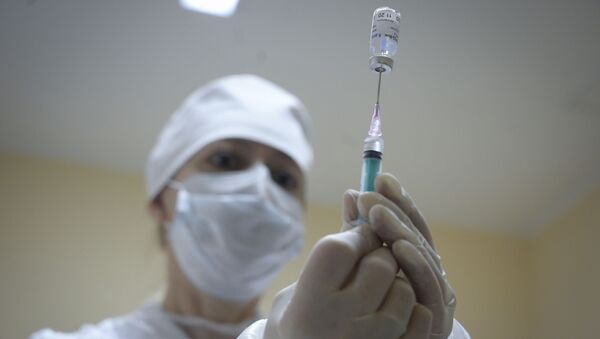 Медработник наполняет шприц российской вакциной от коронавируса Спутник V - Sputnik Литва