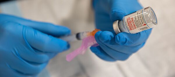 Медицинский работник набирает в шприц вакцину против коронавируса Moderna Covid-19 - Sputnik Литва