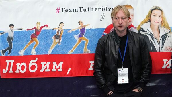 Тренер Евгений Плющенко стоит у баннера в поддержку воспитанников команды Этери Тутберидзе - Sputnik Литва