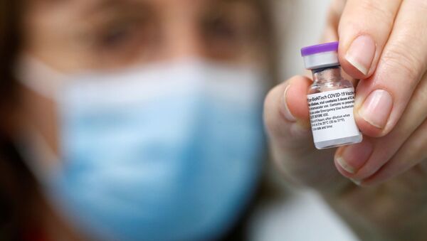 Вакцина против COVID-19 Pfizer-Biontech в руке медицинского работника - Sputnik Литва
