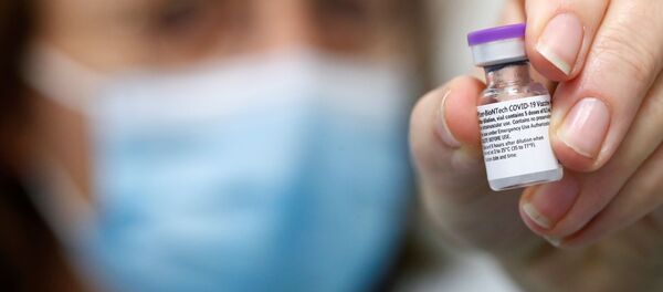 Вакцина против COVID-19 Pfizer-Biontech в руке медицинского работника - Sputnik Литва