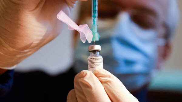 Вакцину против COVID-19 Pfizer-Biontech медик набирает в шприц - Sputnik Литва